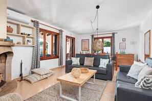 Una sala de estar con chimenea, sofá y una mesita de centro.