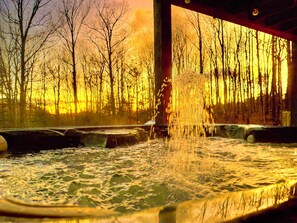 Une zone de sources chaudes offrant une vue sur une forêt au coucher du soleil.