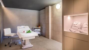 Relax in a serene space with a neatly arranged bed, a comfortable chair, and a calming atmosphere.