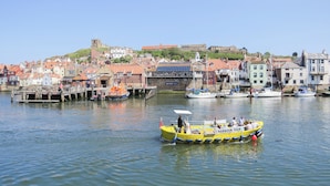 Un puerto con barcos, un muelle y edificios al fondo.