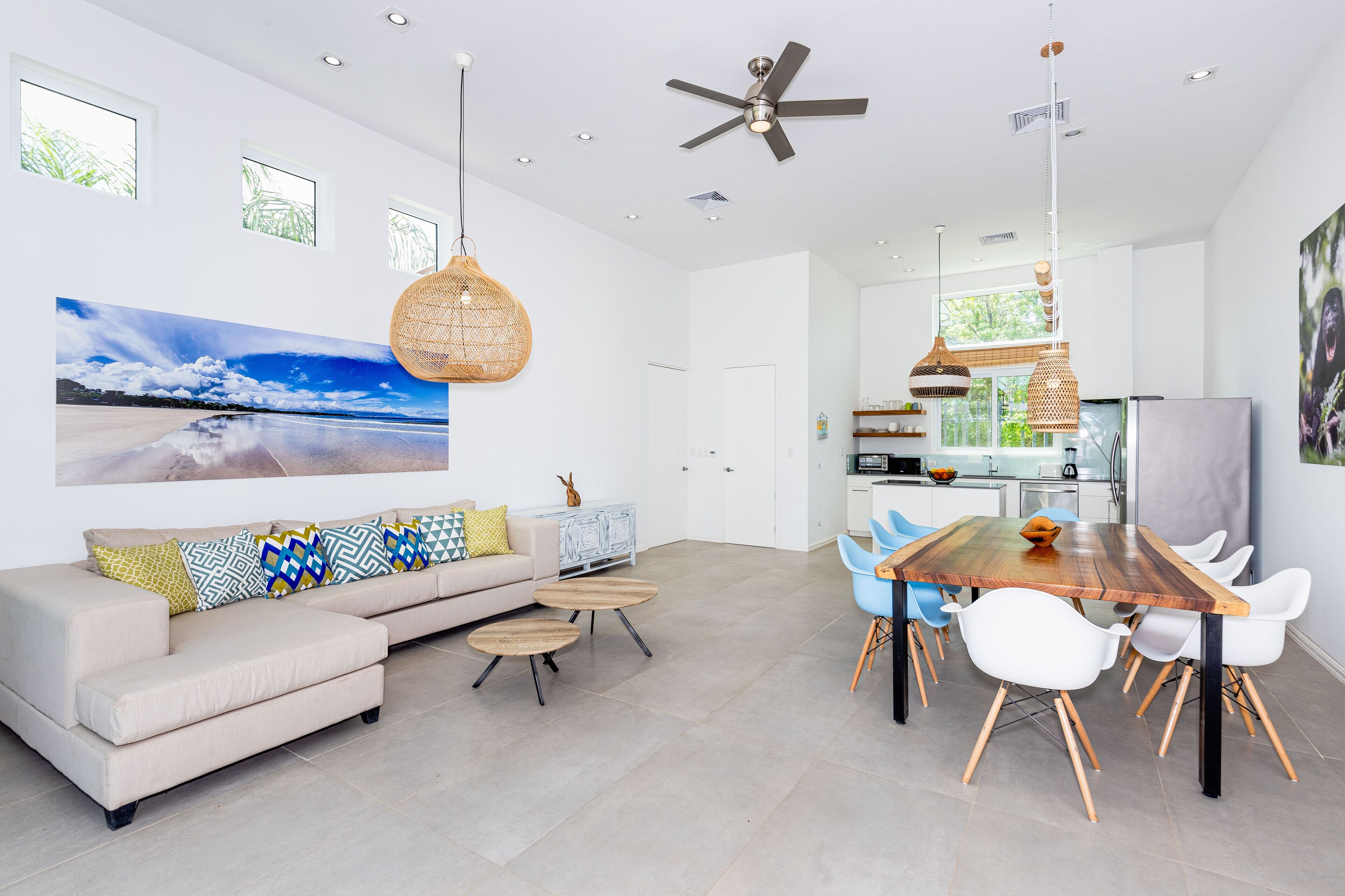 Un salon spacieux comprenant un canapé, une table basse et un coin repas avec des chaises et une table en bois.