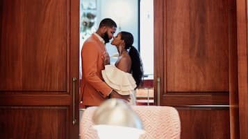 A couple kissing in a wooden arched doorway.