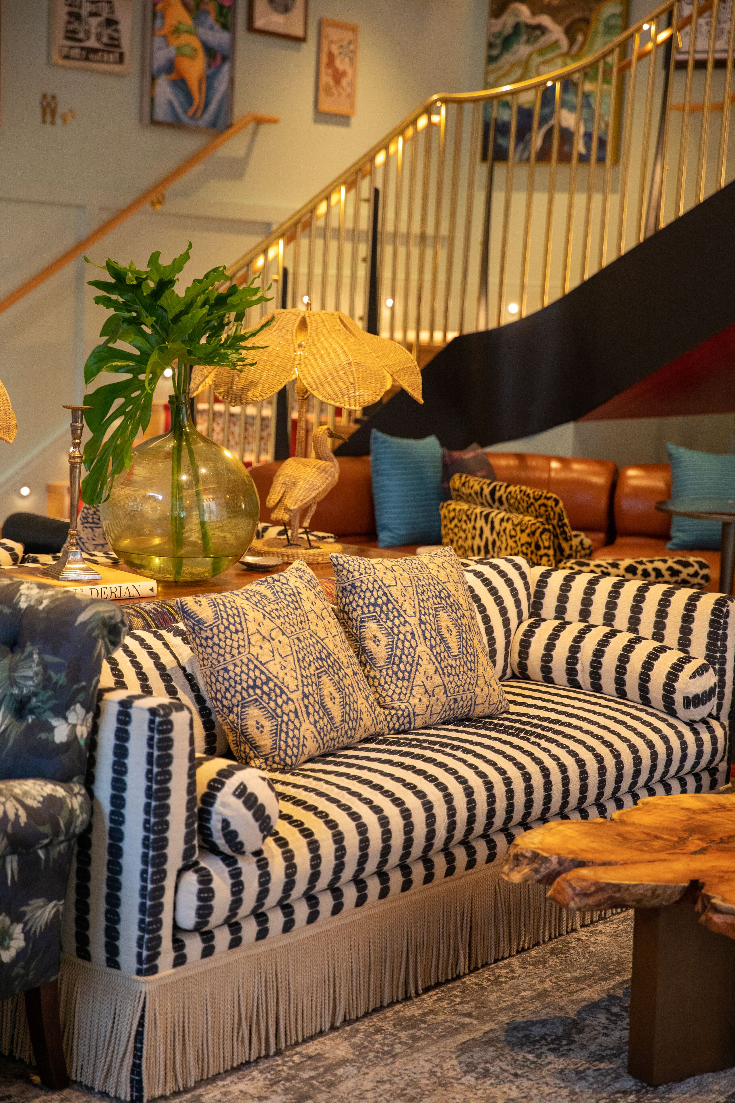 Una sala acogedora con un sofá estampado, una mesa de centro de madera y un jarrón decorativo con una planta.