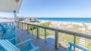 A wooden deck with blue chairs overlooking a beach and ocean. - 5848- Sun & Sea time - Oceanfront Escape | Pool, Hot Tub, Sleeps 18 (Nags Head)