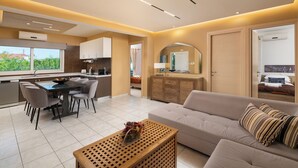 A modern living room with a sofa, dining table, and kitchen area.