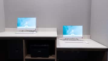 Two computer workstations with monitors, keyboards, and mice on a white desk.