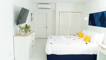 Een moderne slaapkamer met een bed, nachtkastjes, een televisie en een kledingkast.