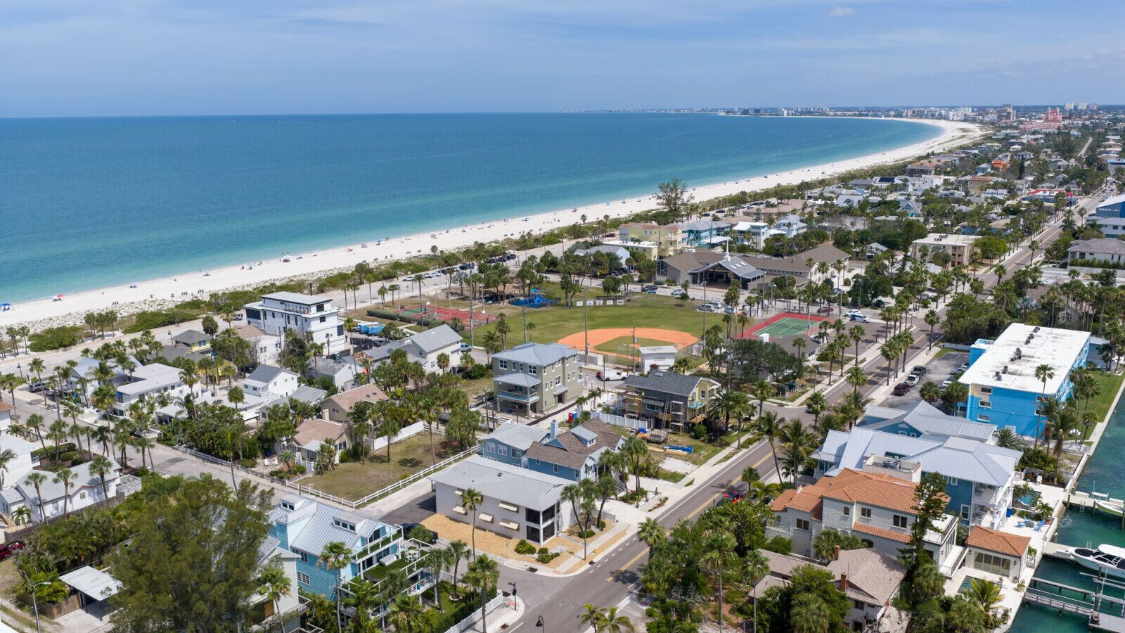 Eine Küstenwohngegend mit Häusern, einem Strand und einem Baseballfeld.