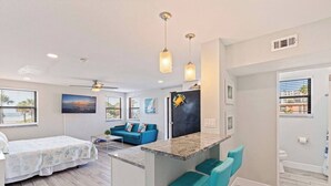 A compact living space with a kitchenette, a dining area, and a bedroom. - Beach-Goers Paradise Getaway! Pool! Sun! Fun! (St. Pete Beach)