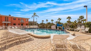 A swimming pool with lounge chairs and a sign indicating no diving. - Prime St Pete Beach Spot • Private Patio (St. Pete Beach)