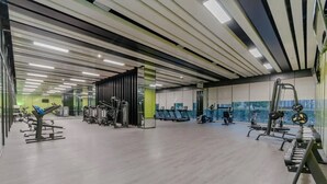 Ein geräumiger Fitnessraum mit unterschiedlichen Trainingsgeräten, darunter Laufbänder und Kraftgeräte.