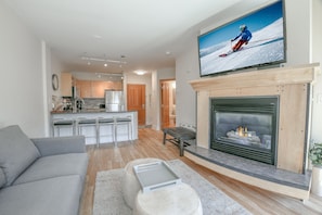 A modern living room with a grey sofa, a fireplace, and a TV mounted above it. - Silver Mill 8225 (Keystone)