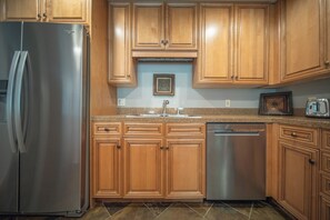 Fully equipped kitchen with refrigerator, dishwasher, and sink.