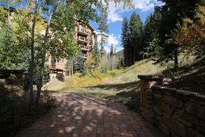 Stunning multi-story building with balconies on each floor, set amidst a serene natural landscape.