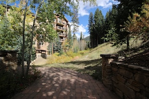 Stunning multi-story building with balconies on each floor, set amidst a serene natural landscape.