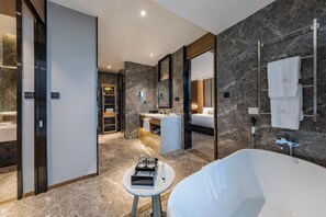 A modern bathroom with a large bathtub, a vanity with a mirror, and a shower area.