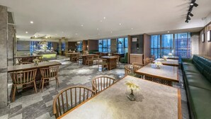 A spacious restaurant with multiple dining areas, including a central bar and a seating area with a green sofa. - Guohui Hot Spring Hotel (Fuzhou)