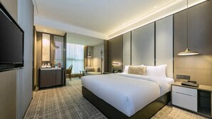 A modern hotel room with a large bed, bedside tables, a desk, and a TV. - Guohui Hot Spring Hotel (Fuzhou)