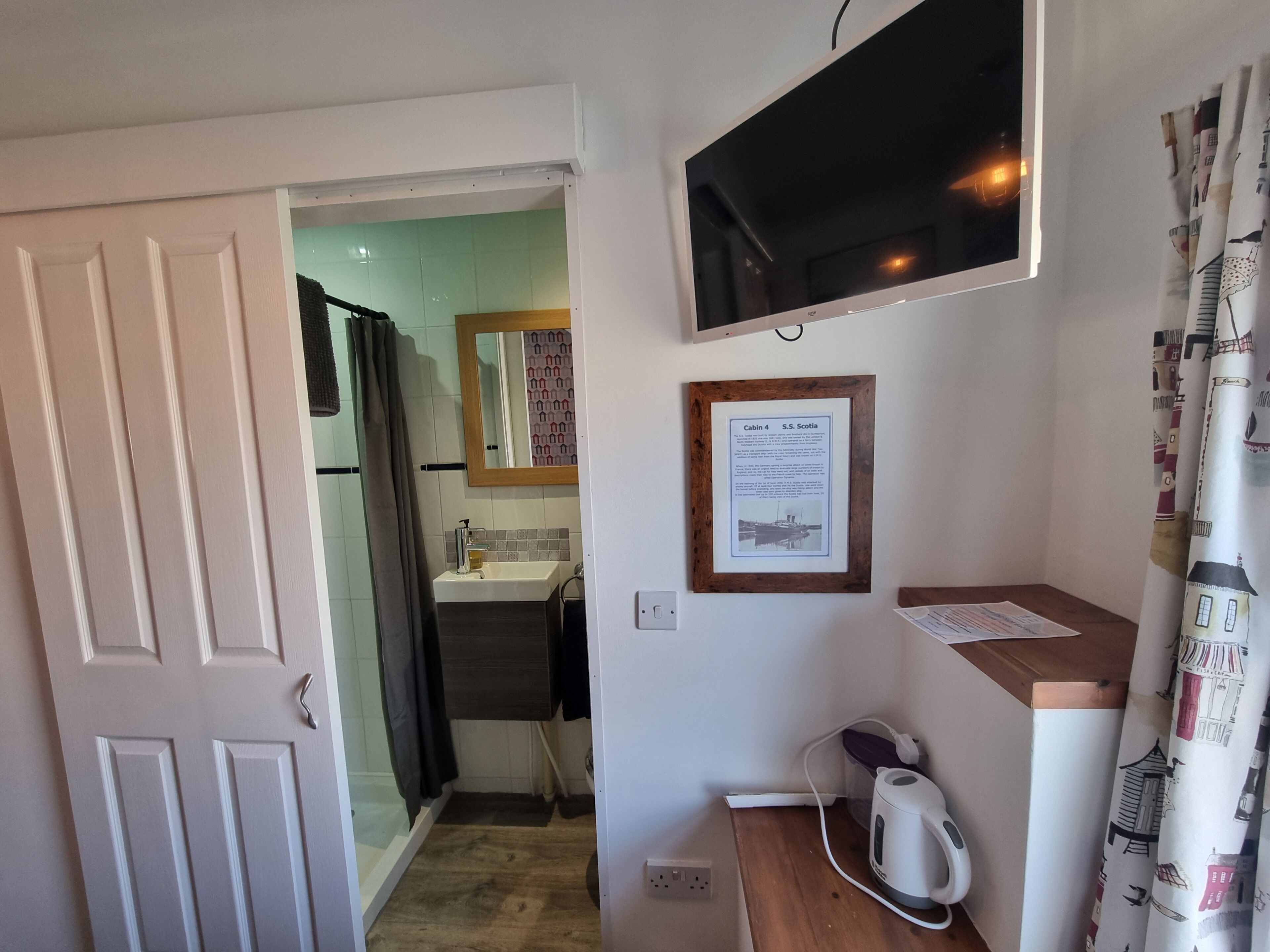 A bathroom with a sink, mirror, and a framed informational plaque.
