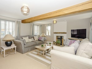 A living room with a sofa, armchairs, a coffee table, a fireplace, a television, and a lamp. - 3 bedroom accommodation in York (York)