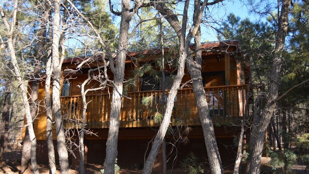 A wooden cabin surrounded by trees. - Whispering Pines - Cabin 31 (Spa Tub) (Pinetop)