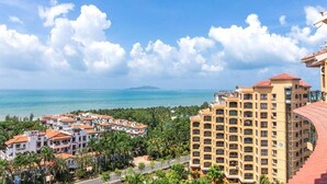 Un hôtel situé sur la côte, composé de plusieurs bâtiments, offrant une vue sur la mer et bordé de palmiers.