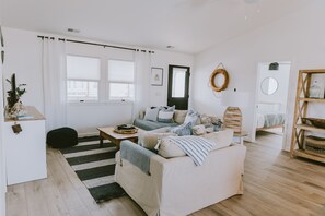 A living room with a sofa, a coffee table, and a bookshelf.