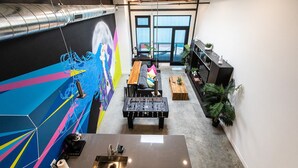 Una cocina moderna con mesa de fútbol, un ventanal grande y un mural colorido.