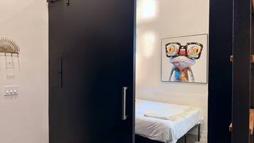 Ein modernes Schlafzimmer mit einem Bett, einer Tür und einem an der Wand befestigten Kunstwerk.
