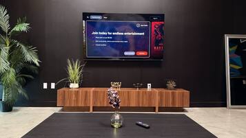 Smart TV on a black accent wall with a wood media console and coffee table.