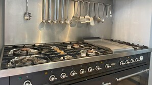 A commercial kitchen with stainless steel appliances, including a stove with multiple burners and a range hood above. - Fairytale castle with heated outdoor pool (Brain-sur-Allonnes)