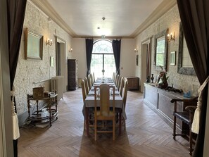 A long dining table with chairs, a radiator, and a cabinet with decorative items. - Fairytale castle with heated outdoor pool (Brain-sur-Allonnes)