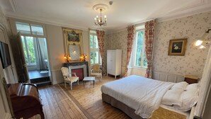 A bedroom with a large bed, a desk, a chair, a fireplace, and a wardrobe. - Fairytale castle with heated outdoor pool (Brain-sur-Allonnes)