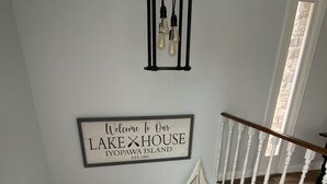 A white staircase with a sign above it that reads "Welcome To Our Lake House Yopawa Island EST. 1980". - Beautiful Lake View IYopawa Island Home. Backs up to Golf Course (Coldwater)