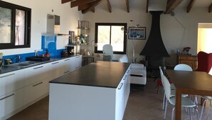 A modern kitchen with white cabinets, a black countertop, and wooden beams on the ceiling. - Single-storey villa, sea view, swimming pool, 5' from beaches, peaceful setting. (Coti-Chiavari)