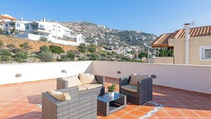 A rooftop terrace with wicker furniture and a view of the surrounding landscape. - Villa with pool and magnificent ocean views half mile from sandy beach (Saronida)
