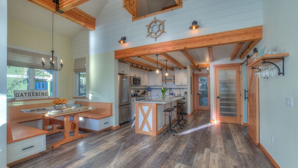 Una cocina amplia con vigas de madera, una isla central y taburetes de bar.