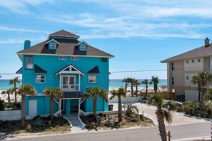 A two-story house with a balcony, located near a beach with palm trees. - Gulf front, pet friendly, and breath-taking views! (Pensacola Beach)