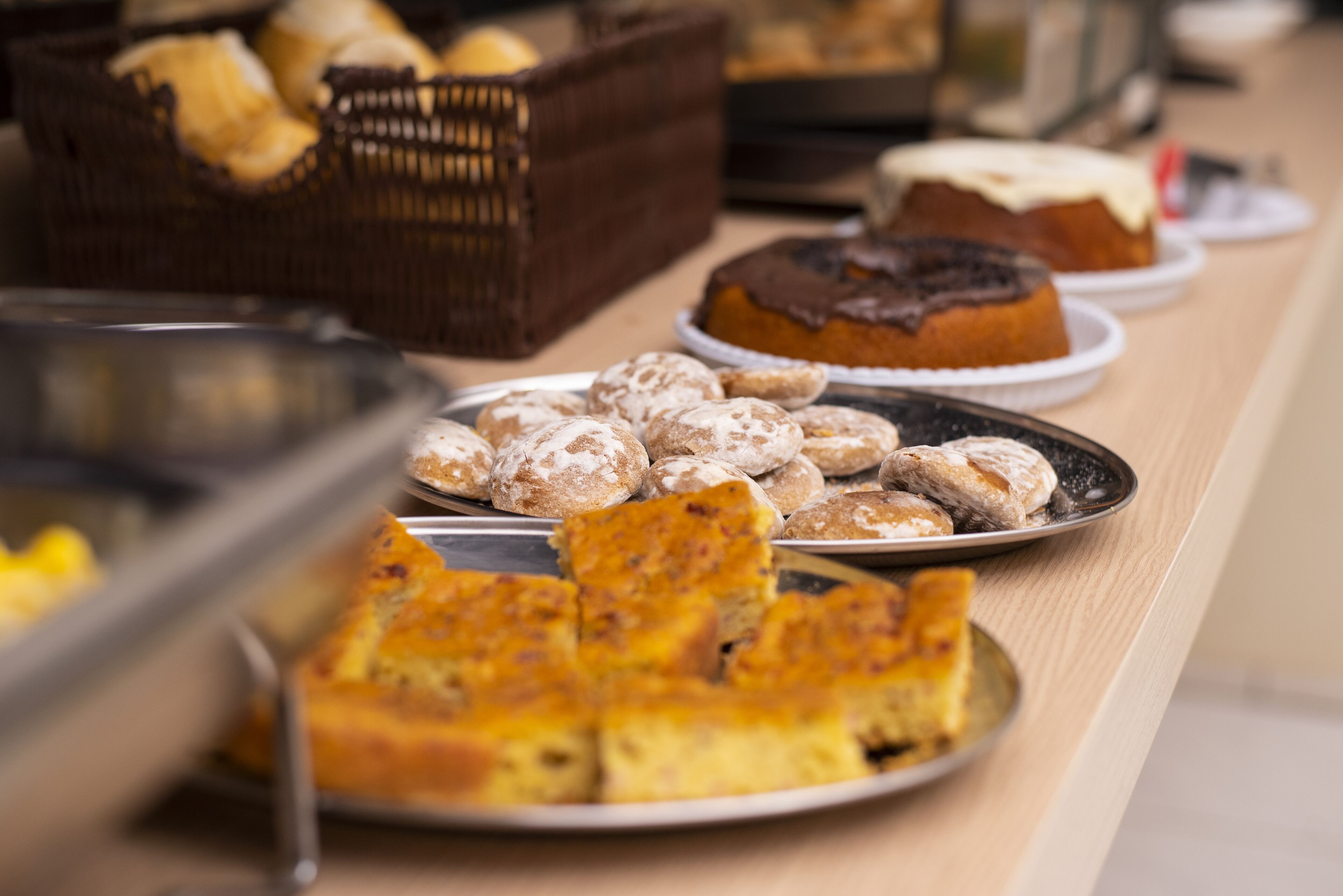 A buffet table with various baked goods including pastries and cakes.