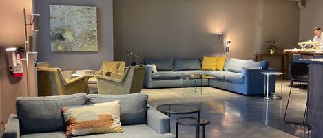 A modern living room with a sectional sofa, a small coffee table, and a framed board game.