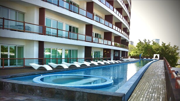 A hotel with a swimming pool, outdoor seating, and a multi-story building with balconies. - Apartments Deck 12 Vallarta (Puerto Vallarta)