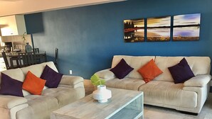 A living room with two sofas, a coffee table, and a painting on the wall. - Apartments Deck 12 Vallarta (Puerto Vallarta)
