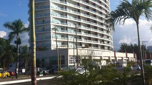 A multi-story hotel with a curved facade, balconies on each floor, and a casino sign at the bottom. - Apartments Deck 12 Vallarta (Puerto Vallarta)