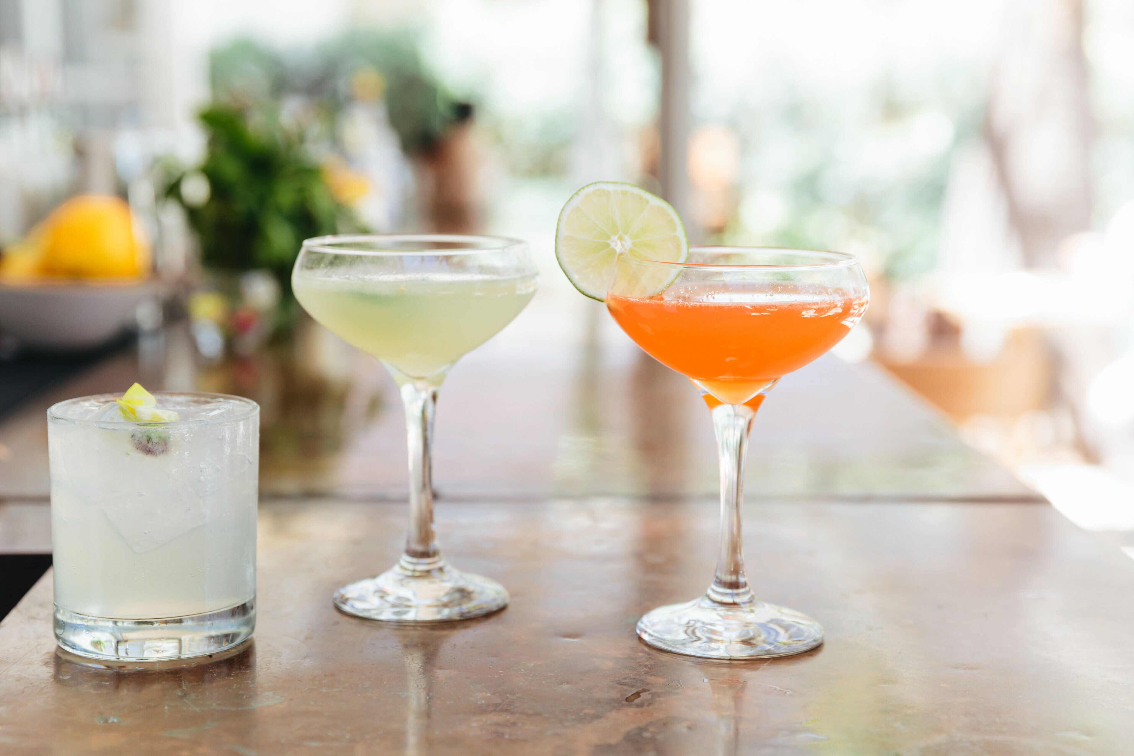 Drie cocktails op een bar.