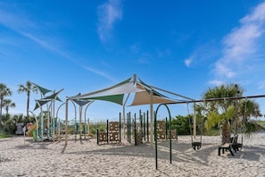 Une aire de jeux de plage avec des structures ludiques et des zones ombragées.
