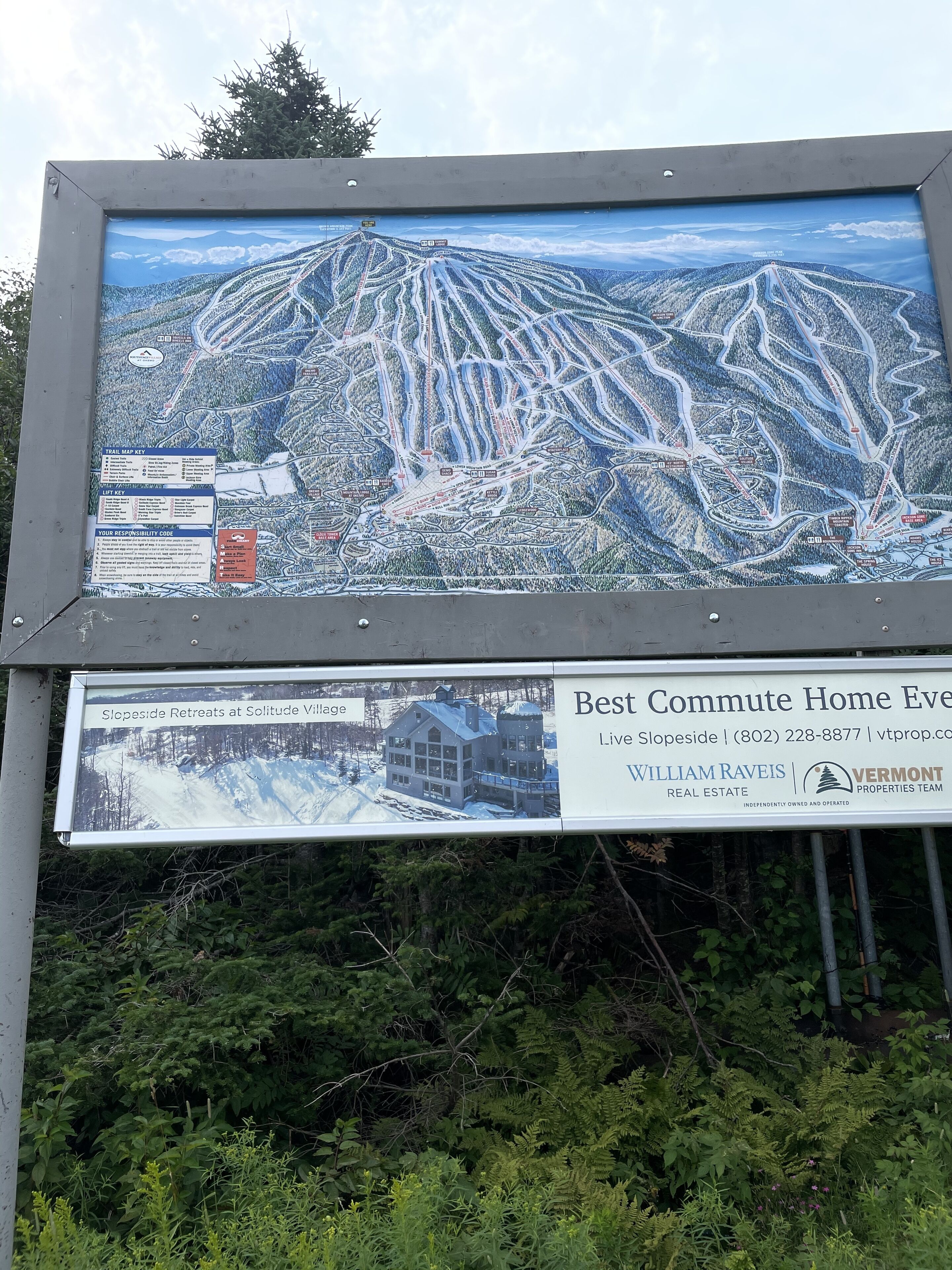 Un panneau indiquant le tracé des pistes de ski et un bâtiment portant l’inscription « Slopeside Retreats at Solitude Village ».