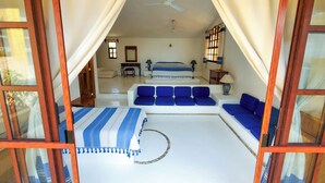 Ein Schlafzimmer mit einem Bett, einem blauen Sofa und einem kleinen Tisch mit einer Lampe.