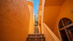 Eine enge Treppe mit gemusterten Stufen, die zu einer Tür führt.
