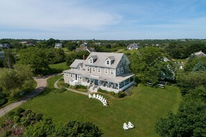 A large, two-story house with a covered porch and a lawn with white chairs. - WALK FROM FERRY!!!    WALK TO TOWN !!!   BIKE EVERYWHERE!!! (New Shoreham)