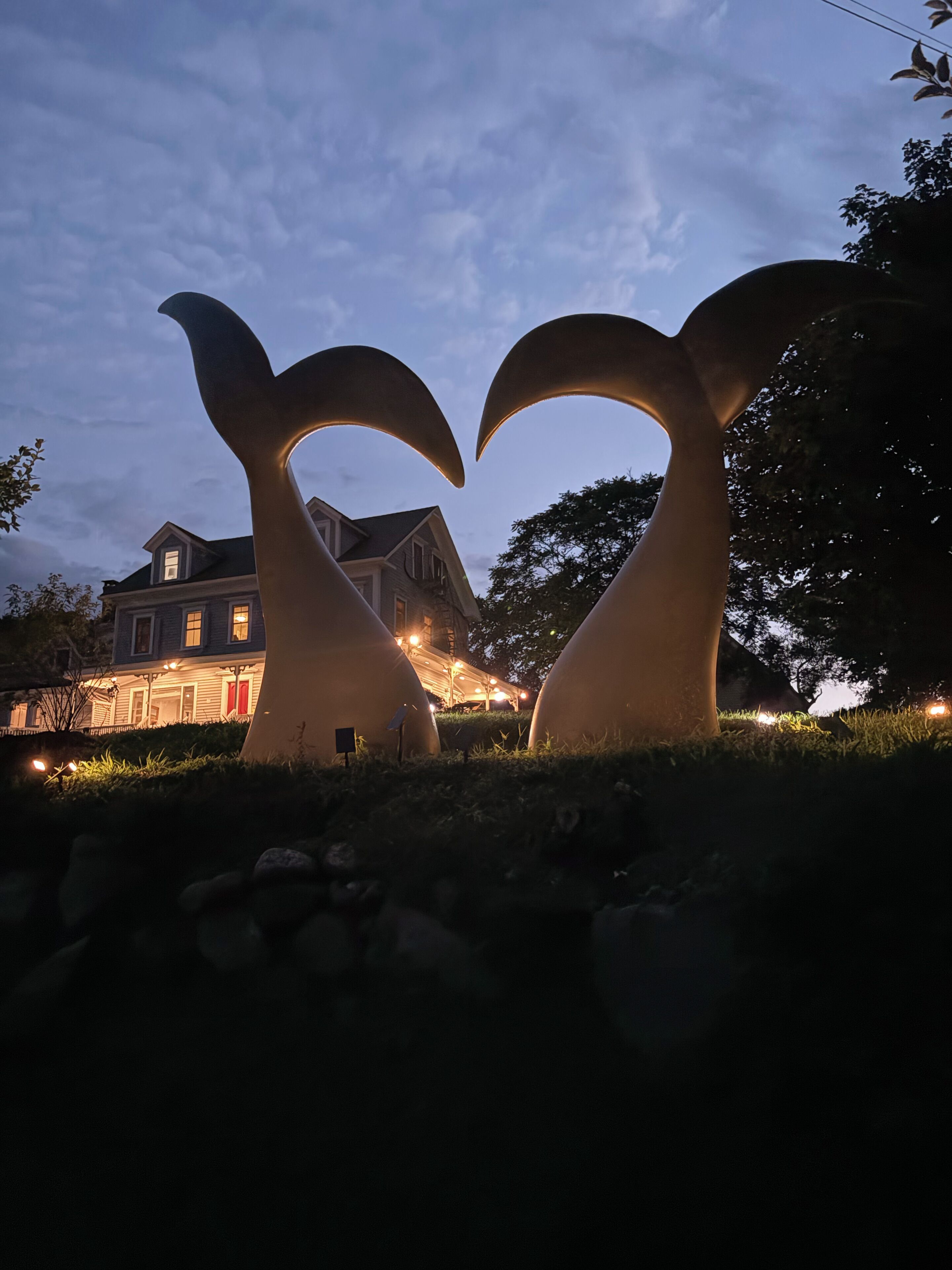 Une maison ornée d’une sculpture unique devant l’entrée.